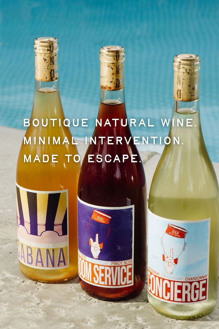 Three bottles of wine with labels on a textured surface and blue gradient background.